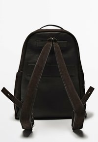 Schwarzer Leder-Rucksack mit glatter Oberfläche und Wildlederriemen. Verfügt über einen oberen Griff und zwei Seitentaschen. Minimalistisches Design, keine sichtbaren Logos.