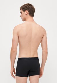 Schwarze Boxershorts aus weichem, dehnbarem Stoff. Verfügt über einen mit Logo geprägten Bund und ein eng anliegendes Design, das sich ideal für den täglichen Gebrauch eignet.