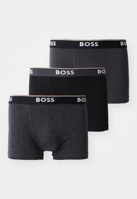 Drei Paar Boxershorts in verschiedenen Schwarz- und Grautönen. Mit einem markierten Bund und einem dezenten Muster bei einem Paar.