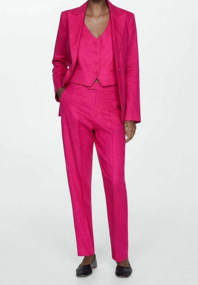 Fuchsia driedelig pak gemaakt van stof met een gladde textuur, bestaande uit een getailleerd colbert, een gilet met drie knopen en taps toelopende broek.