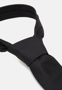 Schwarze Fliege aus strukturiertem Stoff, mit einem traditionellen Design, schmaler Breite und einer glatten Oberfläche im Knotenbereich.