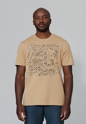 T-shirt en coton beige avec un design graphique noir représentant des montagnes, des arbres et une rivière sinueuse, avec des accents de nuages et de soleil.