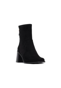 Stivale alla caviglia in pelle scamosciata nera con forma affusolata, tacco a blocco solido, dettagli di cucitura sottili e un piccolo accento dorato sul lato.