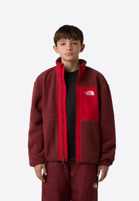 Κόκκινο και μαρόν φλις μπουφάν με φερμουάρ μπροστά, ρυθμιζόμενες μανσέτες και τσέπη στο στήθος με λογότυπο. Διαθέτει απαλή υφή και κουτί σχεδιασμό.