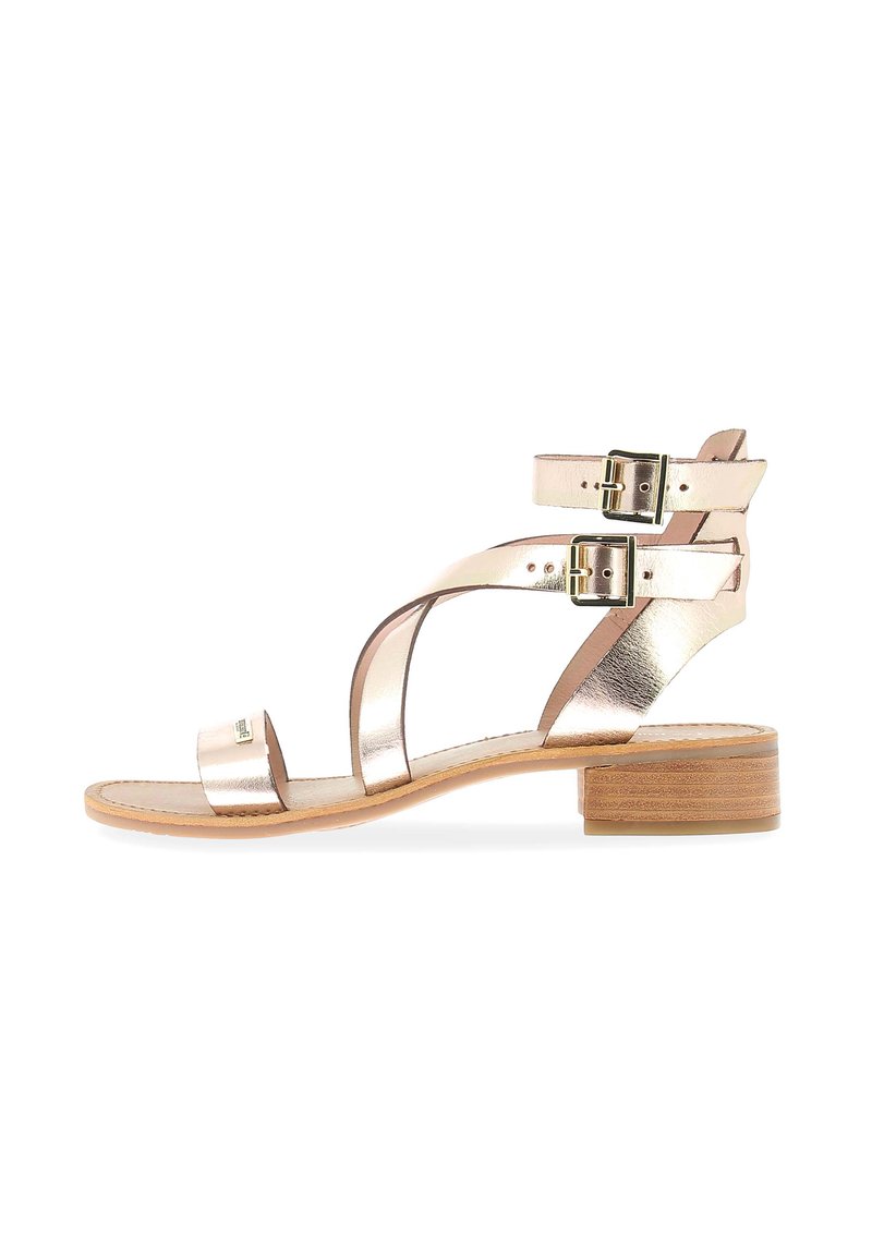 Sandalias metálicas rosas con un bajo tacón cuadrado, que cuentan con hebillas dobles ajustables y tiras entrelazadas. Parte superior de piel suave con una suela natural.