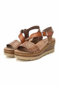 Sandalias de cuña de piel marrón con detalles perforados. Correa de tobillo ajustable, plantilla acolchada y suela texturizada beige.
