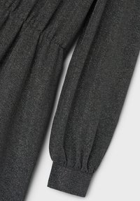 Zwarte, gestructureerde stof met metallic draad, met een design van gesteven mouwen en elastische manchetten. Gladde afwerking met een subtiele glans.