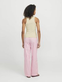 Beige ribbet tanktop parret med pink og hvide lodrette stribede brede bukser; tekstur glat, stof letvægts, afslappet pasform.