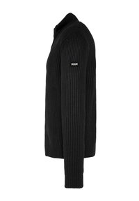 Suéter negro de punto con textura acanalada, que presenta un alto cuello y mangas largas. Incluye un pequeño parche con el logo en el hombro izquierdo.