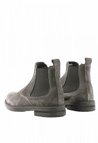 Stivali Chelsea in suede grigio con pannelli elastici laterali, punta rotonda e una robusta suola in gomma nera. Pratiche linguette sul retro.