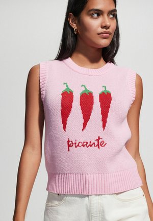Roza bezrukavna pulover s tri crvene ljute paprike i riječju "picante" u kurzivu. Pleteni uzorak s rebrastim rubom.