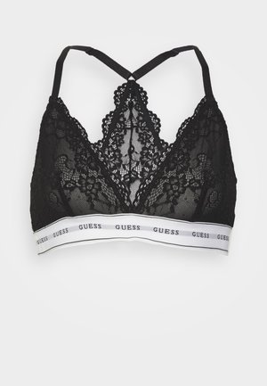 Zwarte kanten bralette met een V-vormig ontwerp, voorzien van kruislings rugbanden en een witte band met "GUESS" in zwart gedrukt.