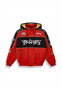 Giacca rossa e nera con cappuccio, caratterizzata da dettagli gialli, numerosi patch, zip visibili e un'autografo sul davanti.