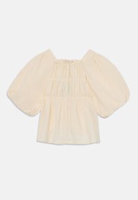 Blusa crema chiara con maniche a sbuffo, texture arricciata e scollatura quadrata. Realizzata in morbido tessuto con una vestibilità morbida e senza chiusure.