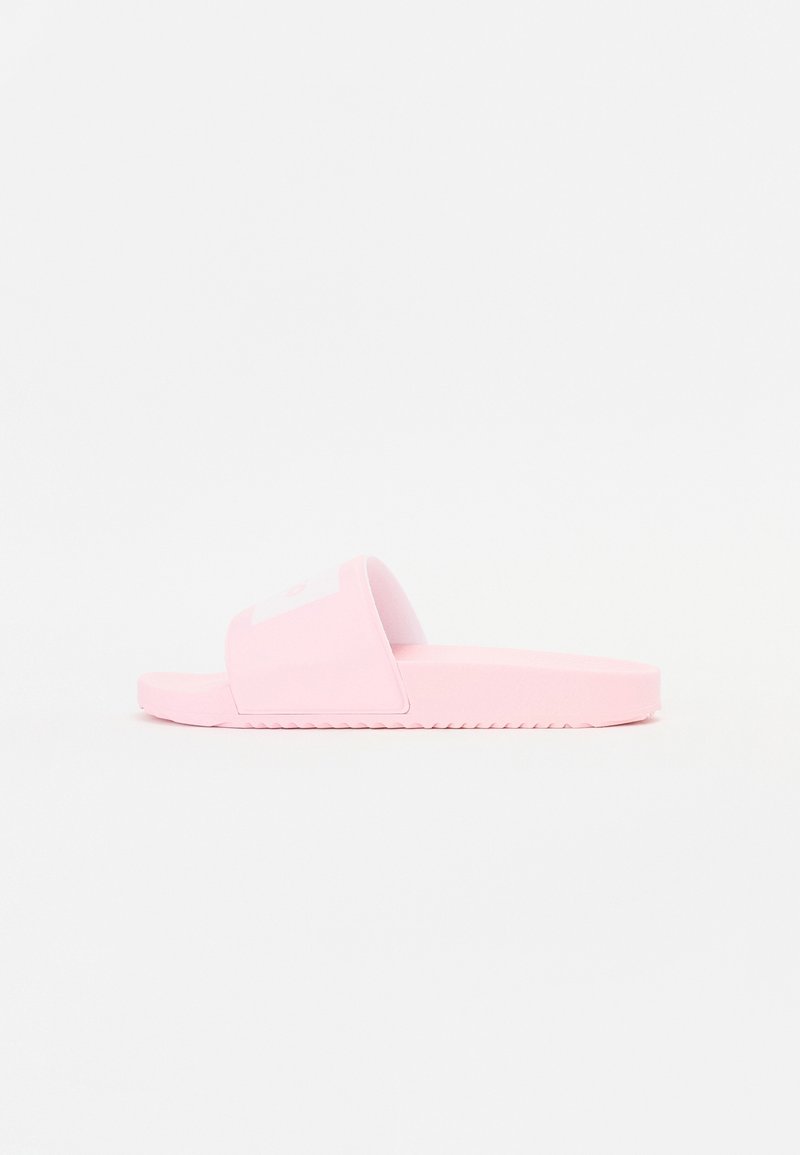 Sandale à enfiler rose en caoutchouc, dotée d'une large bride et d'une semelle texturée avec des rainures horizontales pour l'adhérence. Pas de logos ni de motifs visibles.