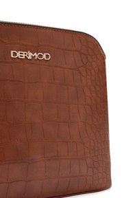 Borsa in finta pelle marrone con texture a coccodrillo, forma elegante e logo dorato "DERİMOD" sul davanti. Chiusura con zip nella parte superiore.