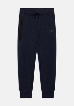 Pantalones de chándal azul marino con cintura ajustable con cordón, puños en las piernas desgastados y un bolsillo con cremallera en el costado que presenta un sutil logo de Nike en el frente.