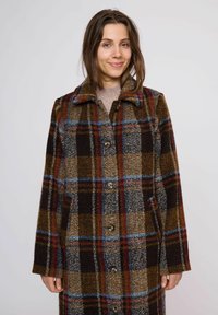 Abrigo de lana a cuadros en colores marrón, gris y rojo, con cuello con solapa, cierre de botones y bolsillos laterales. Textura suave.