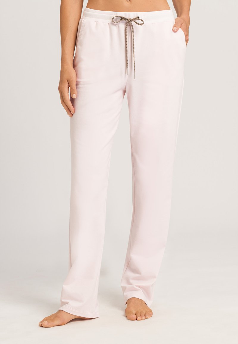 Lichtroze loungebroek van zacht materiaal, voorzien van een elastische tailleband en een decoratieve trekkoord met een bruine accenten.