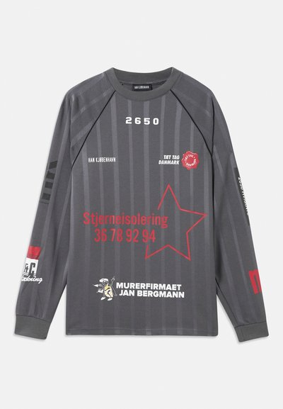 Camisa de manga longa cinza escuro com riscas verticais, gráfico de estrela vermelha e texto em branco e vermelho, incluindo "Stjerneisolering" e "Murerfirmaet Jan Bergmann."