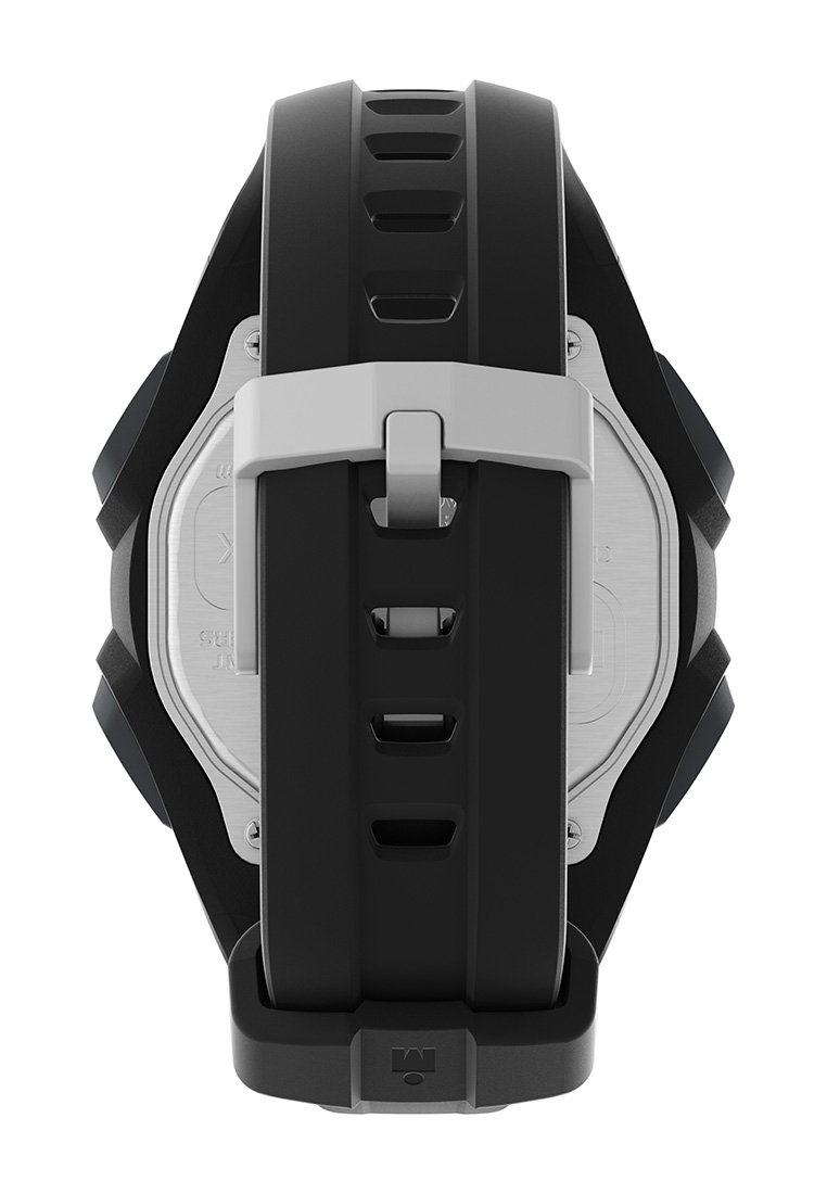 Correa de reloj de goma negra con hebilla de plata, con un diseño texturizado y ranuras de ventilación. Caja de acero inoxidable visible en la parte trasera.