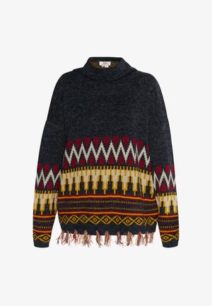 Sötét szürke kötött pulóver magas gallérral, piros, sárga és fehér színekben tarka geometrikus mintákkal, valamint bojt részletekkel az alján.