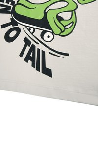 Bílý bavlněný tričko s černým a zeleným grafickým designem ruky na skateboardu a nápisem "FROM TO TAIL". Hladká textura, ležérní styl.