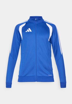 Veste de sport bleue en tissu lisse, avec des accents blancs, un col montant, des manches longues, une fermeture éclair et un logo sur la poitrine.