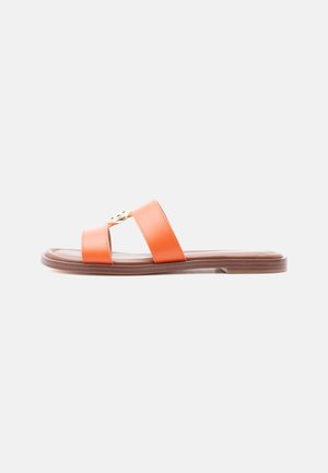 Orange flat slide sandal with two wide straps and a small gold decorative emblem, brown sole, photographed against white background.