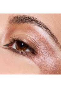 Primo piano di un occhio con iride marrone, ciglia ben definite e ombretto metallico rosa, con un sottile eyeliner nero che delineano la palpebra superiore.