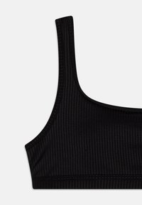 Top in morbido tessuto nero a costine con spalline larghe, scollatura arcuata e texture liscia, caratterizzato da cuciture a contrasto lungo i bordi.