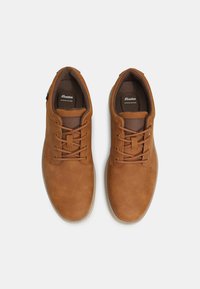 Braune Lederschuhe mit runden Zehen, Schnürdesign, strukturiertem braunem Futter und einer hellen Gummisohle. Verfügt über ein minimales Branding.