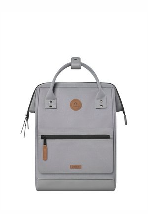 Gray backpack made of durable fabric with a rectangular shape, front zip pocket, leather accents, and top handle for carrying.