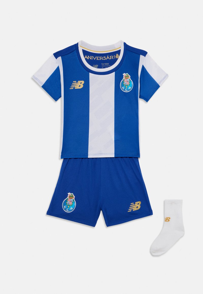 Camisola de futebol azul e branca com mangas curtas, apresentando o logótipo do clube bordado e detalhes em dourado. Inclui calções a condizer e uma meia branca.