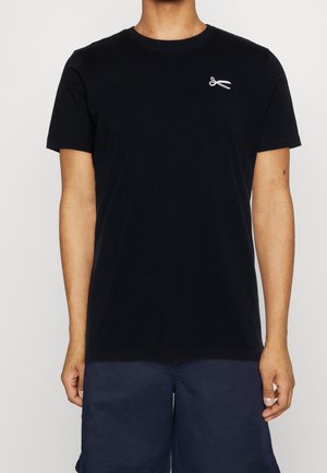 Zwart katoenen t-shirt met korte mouwen en een ronde halslijn. Heeft een klein wit schaarlogo op de linkerborst.