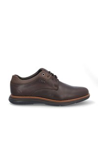 Zapatos de cuero marrón con textura suave, que presentan un diseño con cordones, costuras en contraste en tono marrón claro, y una suela flexible de goma negra.