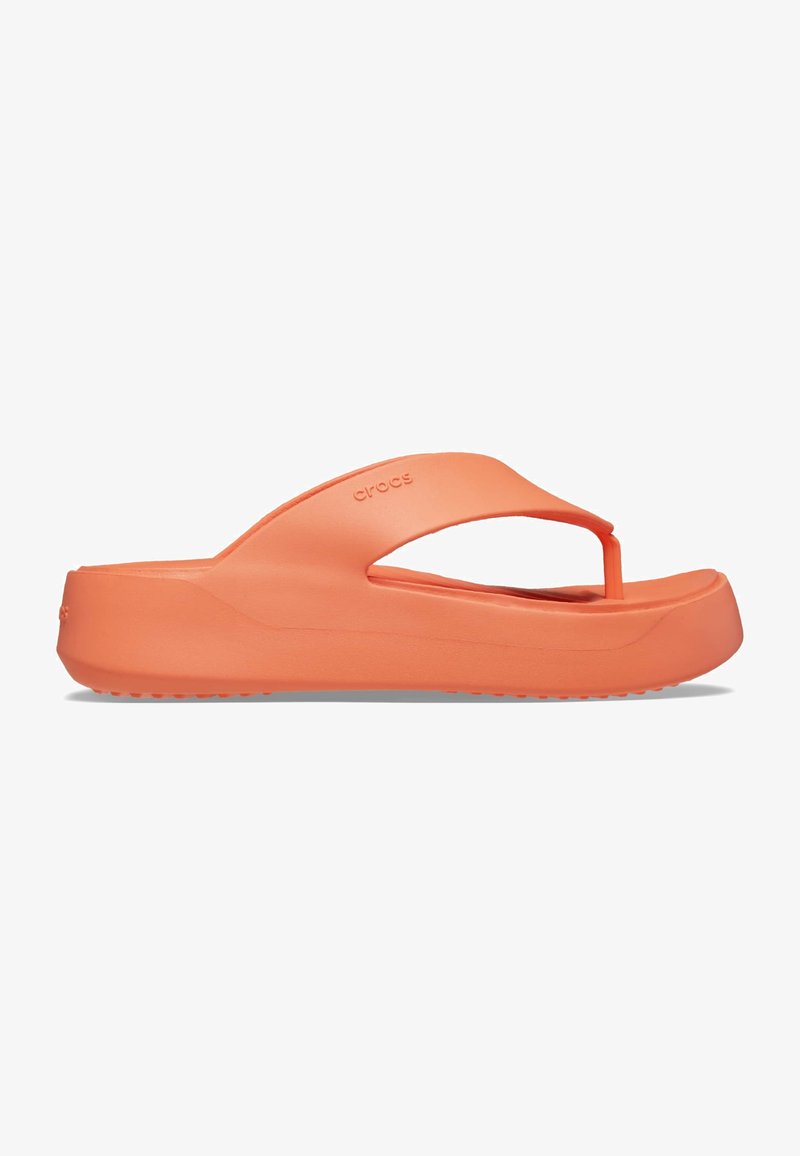 Tongs orange en matériau léger, avec un design de bride entre les orteils, une semelle texturée et une plateforme légèrement surélevée.