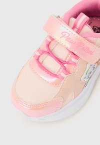 Ροζ αθλητικό παπούτσι με γυαλιστερό φινίρισμα, που διαθέτει ιμάντα με βέλκρο, υφασμάτινες επιφάνειες με υφή και διακόσμηση Paw Patrol. Σχεδιασμός με στρογγυλεμένη μύτη.