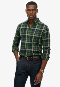 Groen en marineblauw geruit overhemd met button-down kraag, van katoen, met witte accenten en een klein logo op de borst, gecombineerd met donkere jeans.