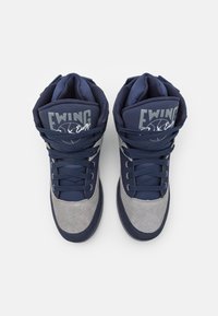 Paio de baskets montantes Ewing bleu marine et gris avec lacets noués, vues de dessus sur fond blanc.