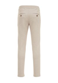 Pantalones de punto beige con diseño de pierna ajustada, cinturilla elástica, dos bolsillos traseros decorados con botones marrones. Textura suave.