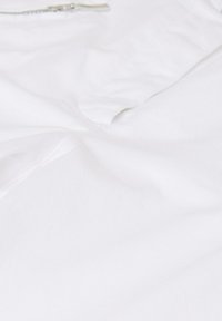 Baumwoll-T-Shirt in einfarbigem Weiß, mit einem schlichten Design, glatter Textur und einem dezenten Reißverschluss an einer Seite für besseren Zugang.