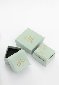 Myntegrønne kasser lavet af tekstureret papir, prydet med et guldfolie logo "elli premium," med en indre sort bund. To kasser arrangeret i vinkler.