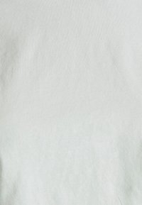 Tela de algodón gris claro con una textura suave y un sutil patrón acanalado, con un acabado suave y sin adornos visibles.