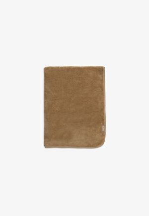 Zachte, bruine rechthoekige deken met afgeronde hoeken en een klein stoffen label aan één kant tegen een witte achtergrond.