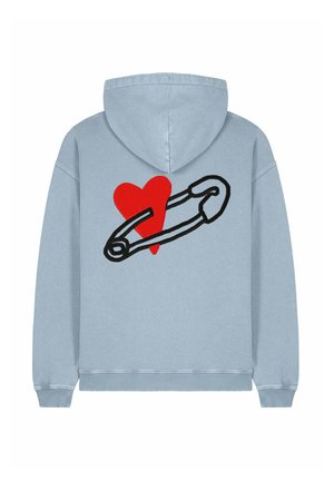 Svetlo modrá mikina s kapucňou so širokým červeným srdcom a čiernym dizajnom bezpečnostnej ihly na chrbte. Mäkká tkanina s voľným strihom a elastickými manžetami.