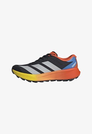 Schwarzer Trailrunning-Schuh mit weißen Streifen, Sohle in Orange- und Gelbverlauf, blauem Fersenakzent und schwarzen Schnürsenkeln mit der Aufschrift "TERREX".