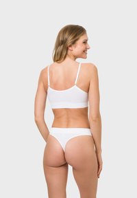 White bra and thong set featuring a smooth fabric, adjustable straps, and seamless design, providing a minimalistic, contemporary look.