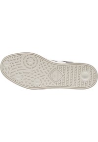 A sola do sapato de borracha apresenta um design texturizado, em branco, com padrões circulares e lineares para tração. Inclui um logótipo na sola.