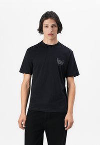 Sort bomulds T-shirt med korte ærmer, rund hals og et lille gråt logo på venstre bryst. Glat tekstur, afslappet pasform.